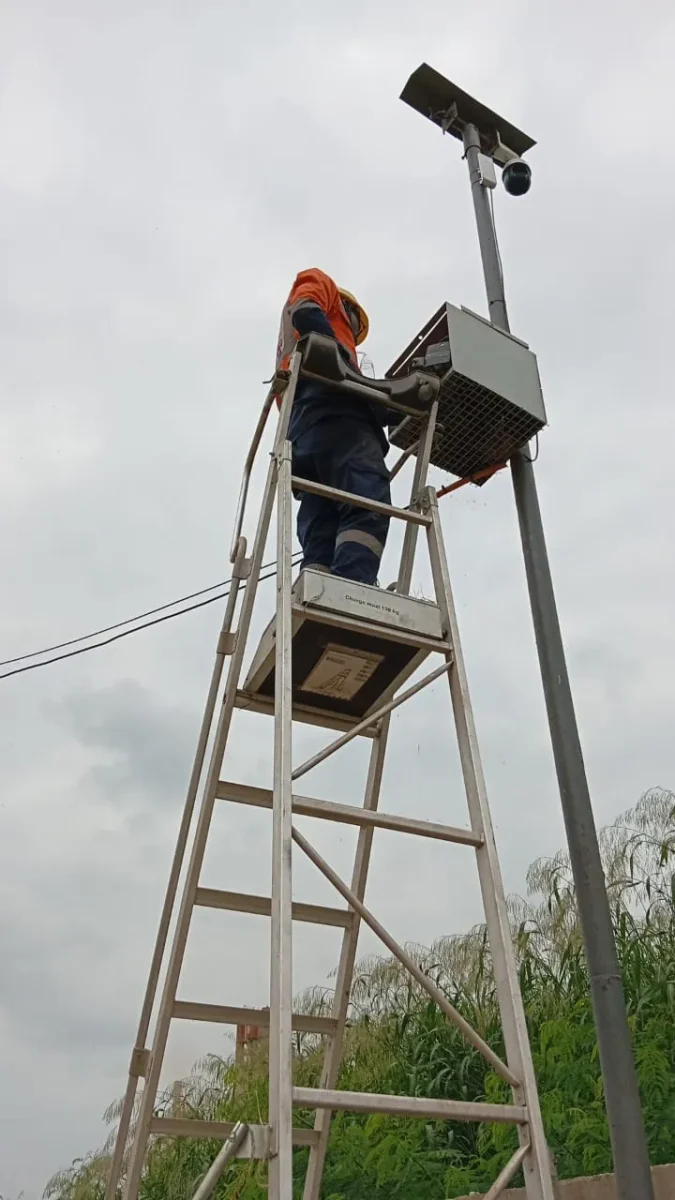 Technicien BTS installant une caméra de surveillance sur un mât